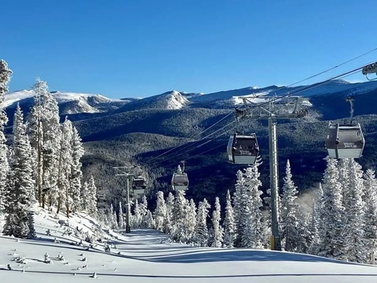 A panoramic winter scene featuring gondola lifts ascending snowy mountain slopes, surrounded by pine trees and mountain ranges. The image captures the adventurous spirit of Winter Park Resort, with fresh snow, skiers, and breathtaking natural views.